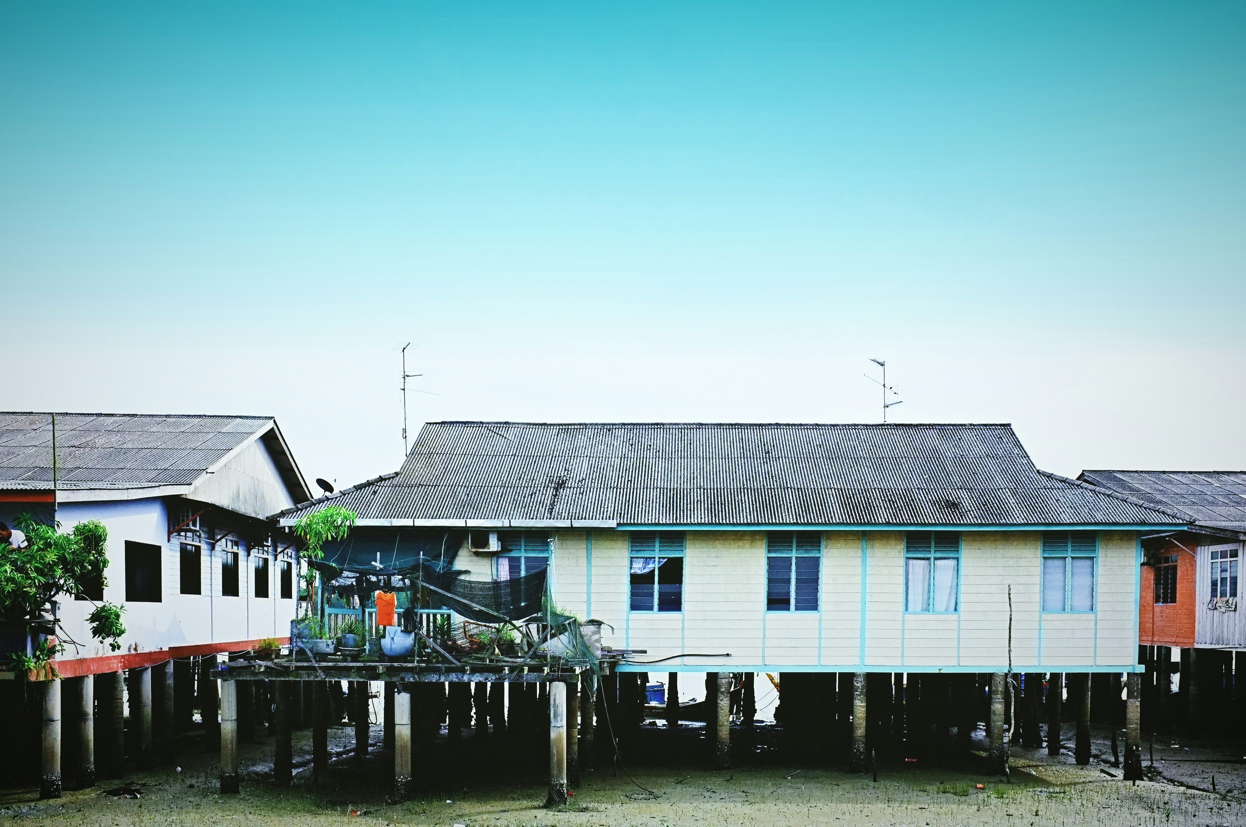 white and blue wooden house near body of water during daytime